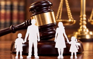 Sagome di una famiglia divisa. Sullo sfondo un tribunale